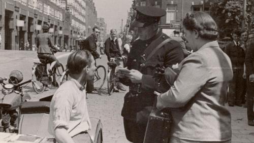 Een politieagent bekeurt op de Vijzelgracht een jongen, 1942