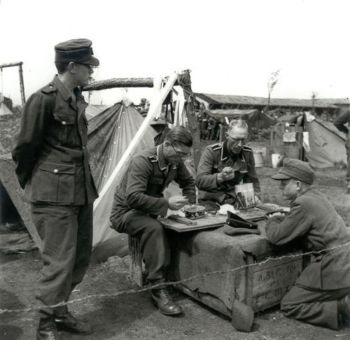 SS en Landwacht, na de oorlog geinterneerd in kamp Harskamp.
<br/>Opnamedatum en fotograaf onbekend.
<br/>Copyright Algemeen Rijksarchief, Postbus 90520, NL-2509 LM, Den Haag.
<br/>Collectie: Anefo, nummer: 900-3396.